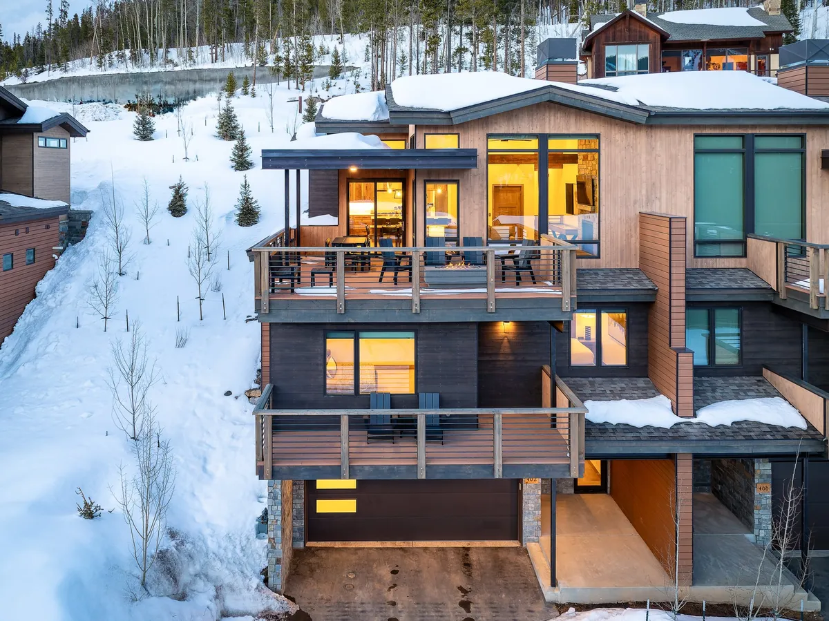 This exterior image showcases a balcony with comfortable seating overlooking a snow-covered landscape. Large windows and the villa’s exterior are visible, suggesting ample space for outdoor gatherings and play. The serene, wintry backdrop invites families to enjoy seasonal activities right outside the door.